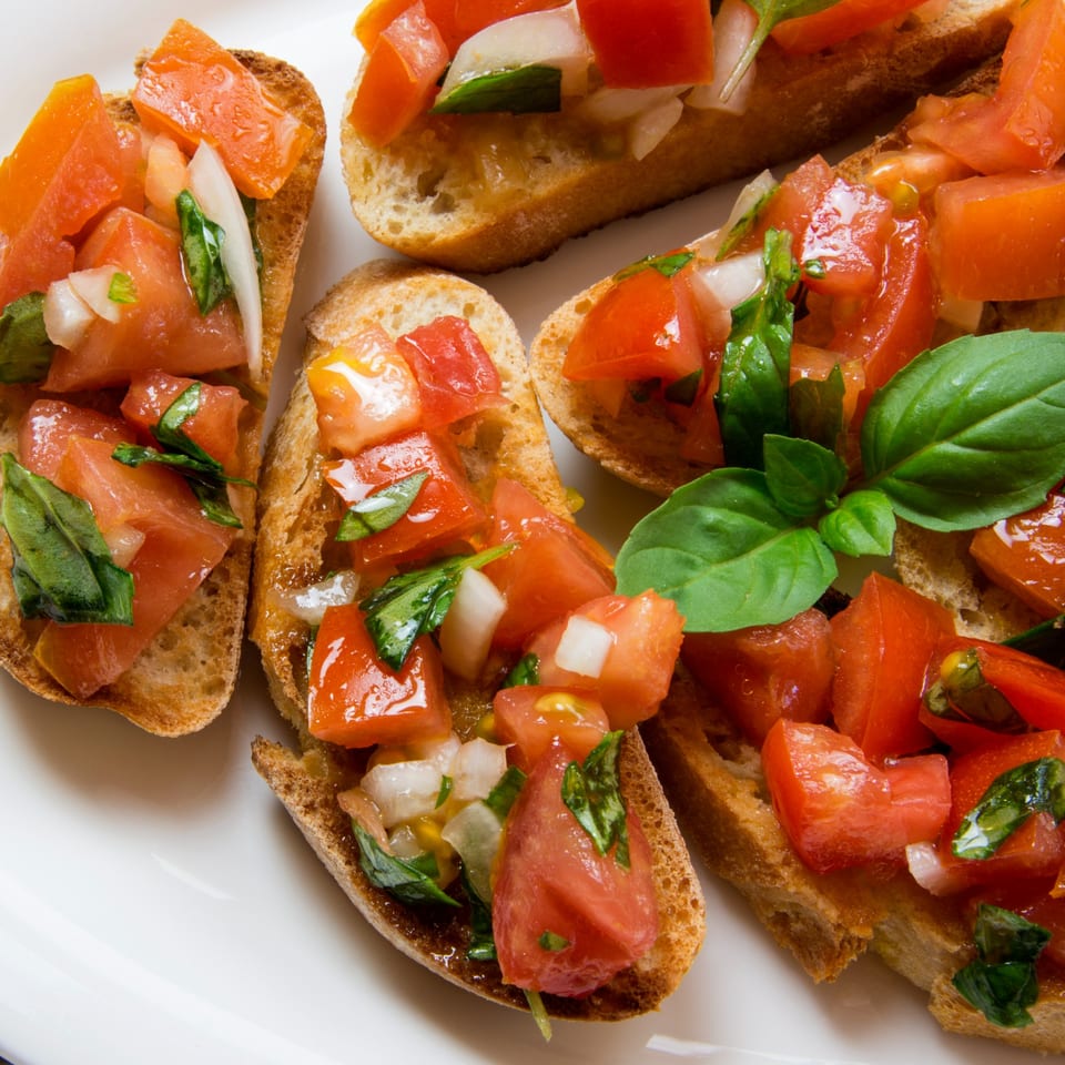 Close-up of Capri Italian Restaurant's bruschetta with diced tomatoes, onions, and basil on toasted bread.